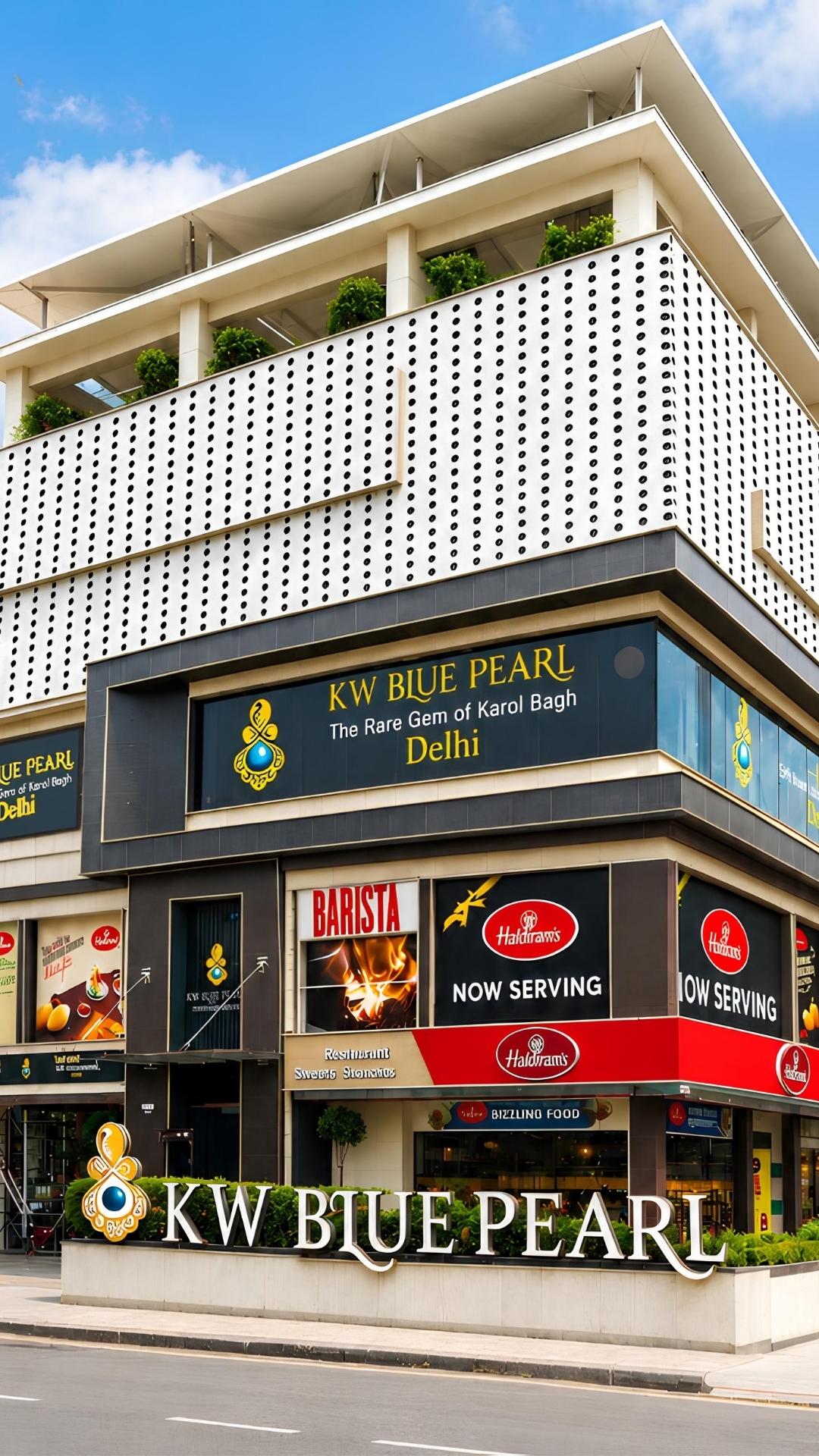 KW Blue Pearl — daylit corner glass facade on DB Gupta Road, Karol Bagh